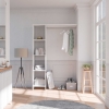 White DELTA wardrobe kit in bright bedroom with shelves, hanging rail and organized storage space.